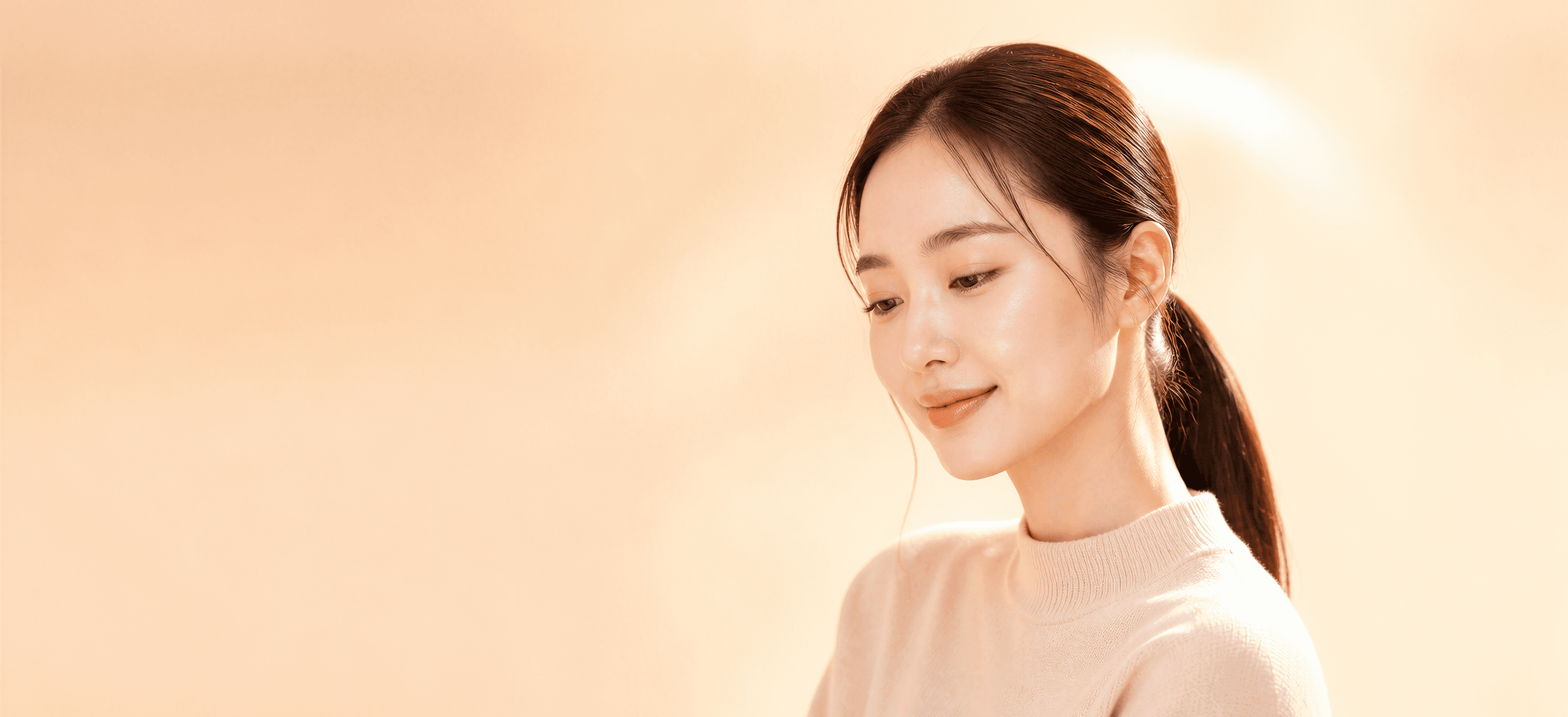 포니테일로 묶은 머리, 매끈한 피부로 잔잔히 미소짓는 측면 프로필
